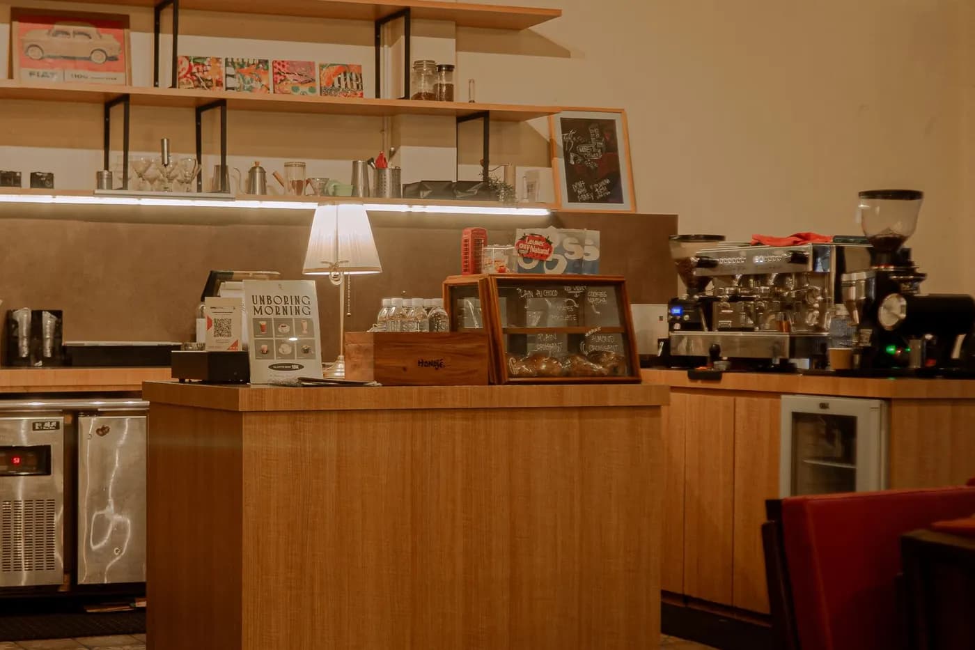 Bright bakery counter with an espresso machine and wooden shelves
