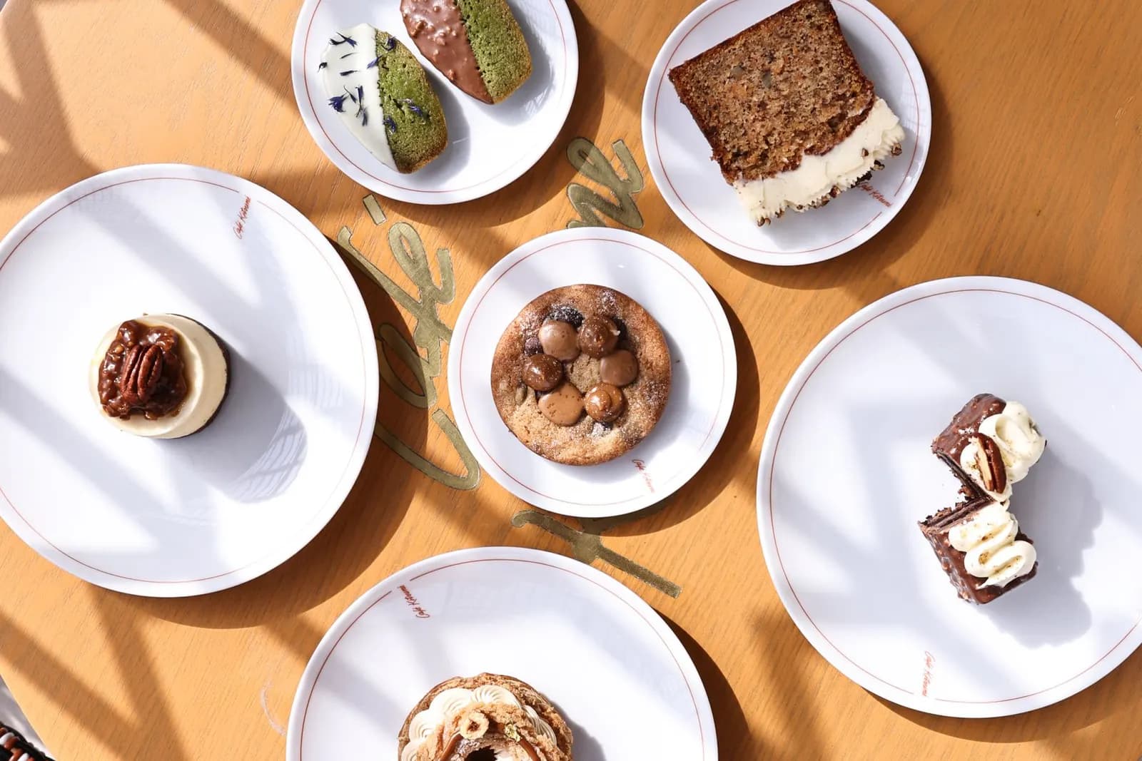 Pastries, cake and cookies on white plates seen from above