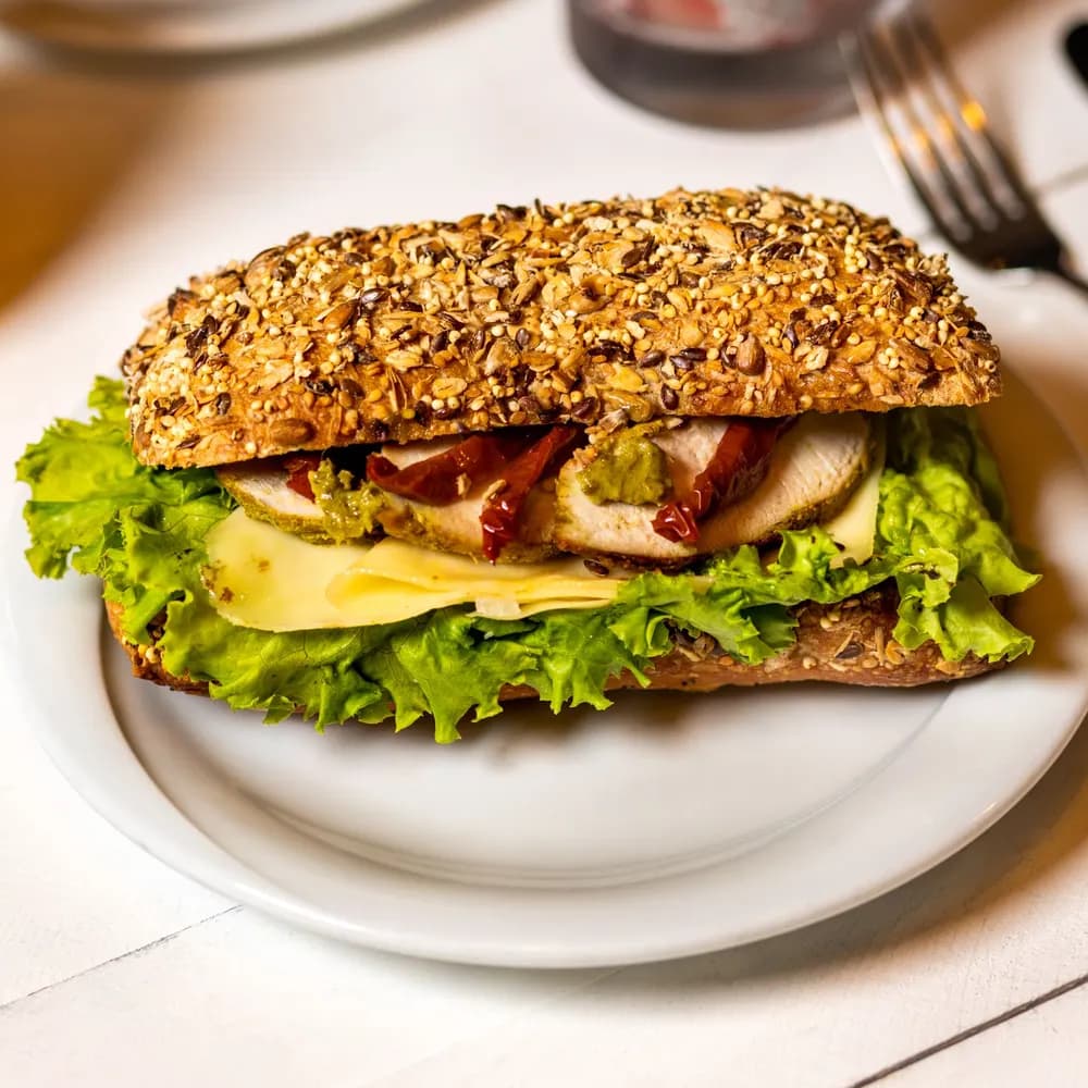 Chicken club sandwich with lettuce and cheese on a seeded multigrain roll