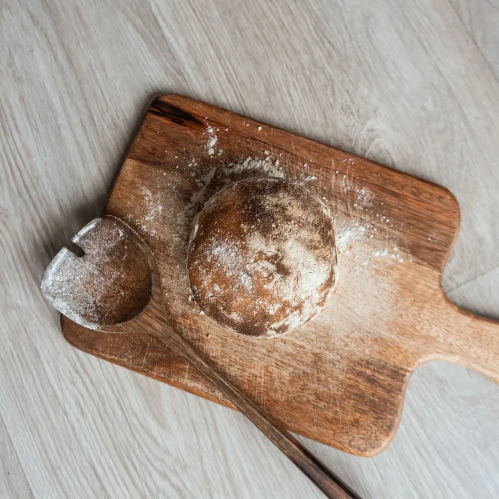 Round loaf of country sourdough bread dusted with flour on a cutting board